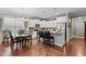 Bright kitchen with stainless steel appliances, white cabinets, decorative décor, a dining table, and hardwood flooring at 1012 Autumn Meadow Ln, Wake Forest, NC 27587