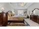 Spacious main bedroom featuring a decorative ceiling, ceiling fan, and dark wood furniture including a dresser and king bed at 1012 Autumn Meadow Ln, Wake Forest, NC 27587