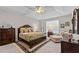 The main bedroom has a tray ceiling, a ceiling fan, a window with blinds, and dark wood bedroom furniture at 1012 Autumn Meadow Ln, Wake Forest, NC 27587