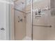 Close up of tiled shower with glass door, shampoo niche, and shower accessories at 1012 Autumn Meadow Ln, Wake Forest, NC 27587