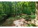 Serene backyard oasis featuring a hammock, red Adirondack chairs, and a storage shed surrounded by trees at 1015 Manchester Dr, Cary, NC 27511