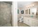 Well-lit bathroom featuring a tiled shower, vanity with storage, and neutral decor at 1015 Manchester Dr, Cary, NC 27511