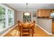 Cozy dining area with a wooden table, chairs, a modern light fixture, and backyard access at 1015 Manchester Dr, Cary, NC 27511