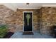 Stylish black front door featuring decorative wreath and secure lock, set in stone exterior at 1015 Manchester Dr, Cary, NC 27511
