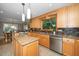 Well-lit kitchen with a center island, stainless steel appliances, and a view into the dining area at 1015 Manchester Dr, Cary, NC 27511