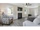 Bright living room with a fireplace, large windows, and neutral decor, showcasing a comfortable seating area at 105 Tactical Dr, Bunnlevel, NC 28323