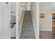 View of carpeted staircase leading upstairs, flanked by a glimpse of a living room and dining area at 105 Tactical Dr, Bunnlevel, NC 28323