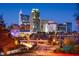 Nighttime view of a vibrant cityscape with illuminated buildings and traffic trails at 10518 Pleasant Branch Dr # 38, Raleigh, NC 27614
