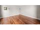 Clean empty room with hardwood floors, white walls and baseboards ready for a new tenant at 111 Gingergate Dr, Cary, NC 27519