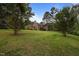 View of a two-story house with a large backyard and mature trees at 12088 Burlington Rd, Hurdle Mills, NC 27541