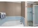 Bathroom featuring tiled shower, bathtub, and towel rack at 12088 Burlington Rd, Hurdle Mills, NC 27541