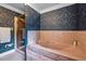 Bathroom featuring a pink tub, glass shower and patterned blue wallpaper at 12088 Burlington Rd, Hurdle Mills, NC 27541