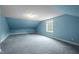 Bedroom with carpet, slanted ceilings, window, blue paint, and offering a cozy retreat at 12088 Burlington Rd, Hurdle Mills, NC 27541