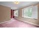 Bright bedroom with large windows, built-in bookshelves, and plush carpet at 12088 Burlington Rd, Hurdle Mills, NC 27541