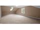 Spacious bonus room featuring neutral paint, carpet, a window, and a skylight for natural light at 12088 Burlington Rd, Hurdle Mills, NC 27541