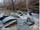 Flowing creek with large rocks, enhancing the natural beauty of the landscape at 12088 Burlington Rd, Hurdle Mills, NC 27541