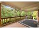 Covered deck overlooking lush backyard, perfect for outdoor relaxation with dark outdoor rug and chairs at 12088 Burlington Rd, Hurdle Mills, NC 27541