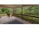 Relaxing covered deck with patterned outdoor rug and natural views at 12088 Burlington Rd, Hurdle Mills, NC 27541