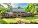 Charming brick two-story home with manicured lawn, mature trees, and inviting walkway at 12088 Burlington Rd, Hurdle Mills, NC 27541
