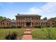Beautiful two-story brick home featuring a well-maintained lawn and classic architectural details at 12088 Burlington Rd, Hurdle Mills, NC 27541