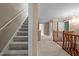 Open hallway featuring carpet, stairs, and wood banister leading to different areas of the home at 12088 Burlington Rd, Hurdle Mills, NC 27541