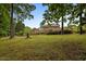 Large brick home on a well-manicured lawn, surrounded by lush trees and landscaping at 12088 Burlington Rd, Hurdle Mills, NC 27541