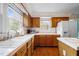 Bright kitchen features wood cabinets, white countertops, and a double sink beneath a large window at 12088 Burlington Rd, Hurdle Mills, NC 27541