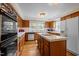 Spacious kitchen with wood cabinets, white appliances, and tile countertops at 12088 Burlington Rd, Hurdle Mills, NC 27541