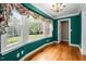 Inviting living room with large windows, hardwood floors, and refreshing green walls and trim at 12088 Burlington Rd, Hurdle Mills, NC 27541