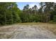 Gravel lot surrounded by trees, suitable for parking and other recreational activities at 12088 Burlington Rd, Hurdle Mills, NC 27541