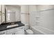 Bathroom features a white vanity with black countertop and shower-tub combo at 121 Gilmer St, Fuquay Varina, NC 27526