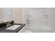 Bright bathroom featuring a shower and tub combination, black countertop, and gold hardware at 121 Gilmer St, Fuquay Varina, NC 27526