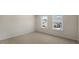 Bright bedroom features neutral walls, carpet, and two windows offering natural light at 121 Gilmer St, Fuquay Varina, NC 27526