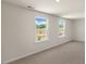 Large bedroom with neutral walls, carpet, and two bright windows at 121 Gilmer St, Fuquay Varina, NC 27526