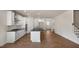 Open concept kitchen featuring stainless steel appliances, white cabinets, and dark countertops at 121 Gilmer St, Fuquay Varina, NC 27526