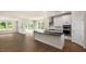 Open kitchen concept flowing into the living area with stainless steel appliances, white cabinets, and large windows at 121 Gilmer St, Fuquay Varina, NC 27526