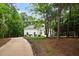 Exterior of a white painted home with a driveway and lush green trees at 12301 Hardee Rd, Raleigh, NC 27614