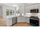 Modern kitchen with stainless steel appliances, white cabinets, quartz countertops, and a view to the backyard at 12301 Hardee Rd, Raleigh, NC 27614