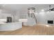 Open-concept living space featuring a fireplace, staircase, chandelier, and built-in desk with modern finishes at 12301 Hardee Rd, Raleigh, NC 27614