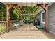 Home's back deck features a pergola, a grill, table, and a green dog bed at 133 Creekstone Dr, Benson, NC 27504