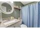 Bright bathroom with modern vanity, round mirror, and a stylish shower curtain for a fresh, clean look at 133 Creekstone Dr, Benson, NC 27504