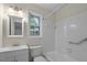 Bathroom featuring a shower-tub combo with white tiles, white vanity and updated fixtures at 136 Sycamore St, Cary, NC 27513