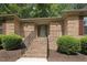 Brick home entrance with brick steps, black handrails, and neatly trimmed bushes at 136 Sycamore St, Cary, NC 27513