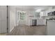 Kitchen featuring white cabinets, stainless steel appliances, and hardwood flooring at 136 Sycamore St, Cary, NC 27513