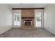 Comfortable living room with a brick fireplace, neutral carpet, and a door to the backyard at 136 Sycamore St, Cary, NC 27513