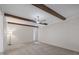 Cozy living room featuring exposed wood beams, neutral carpet, and a modern ceiling fan at 136 Sycamore St, Cary, NC 27513