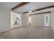 Living room with exposed wood beams, carpet, and an open view to the kitchen at 136 Sycamore St, Cary, NC 27513