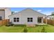 View of fenced backyard with raised garden beds and patio doors at 1401 Justice Union Ct, Raleigh, NC 27604