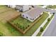 Aerial view of fenced backyard featuring small evergreens and raised garden beds at 1401 Justice Union Ct, Raleigh, NC 27604