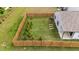 Aerial view of fenced backyard with small evergreens and raised garden beds at 1401 Justice Union Ct, Raleigh, NC 27604
